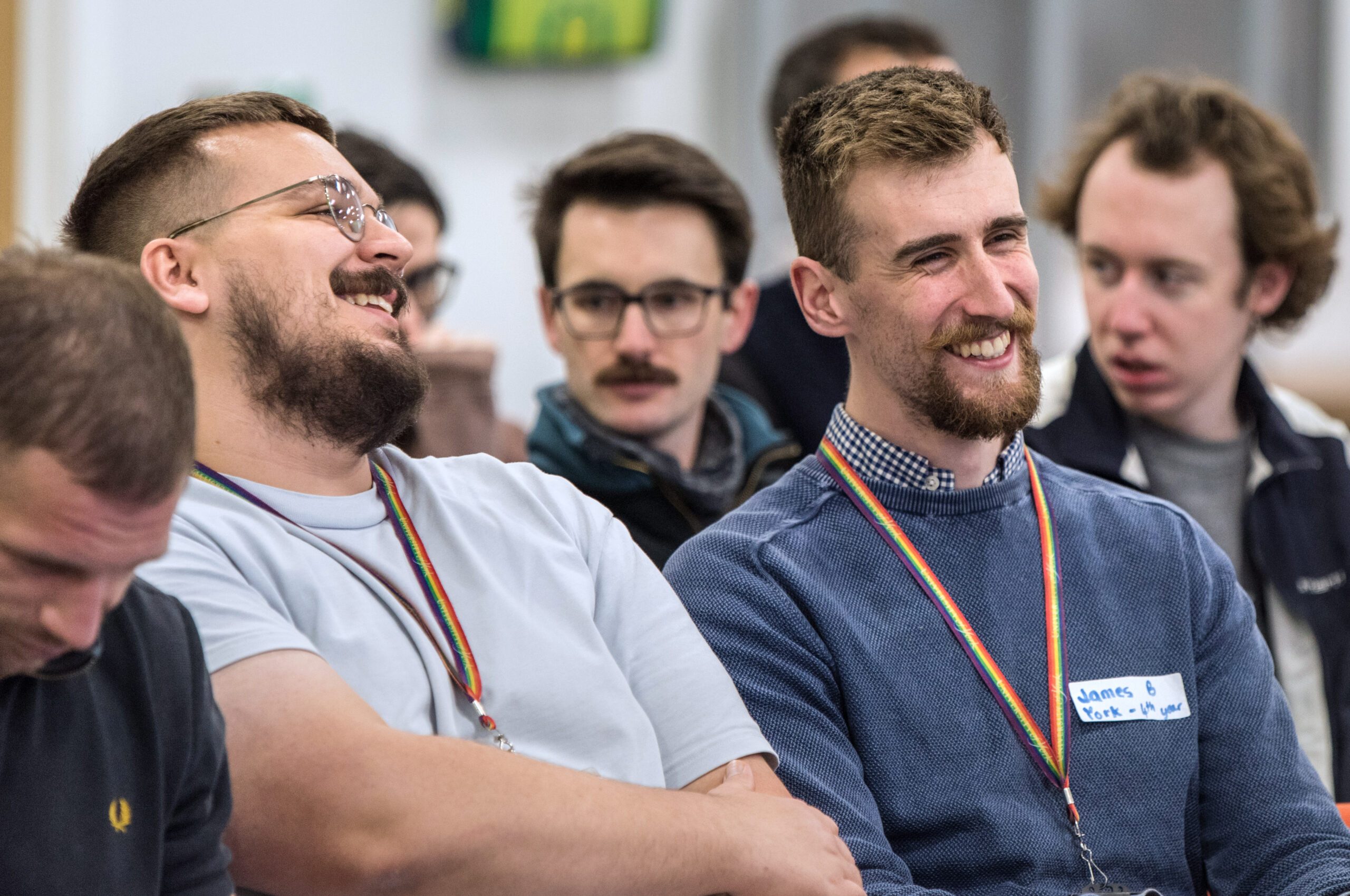 A close up photograph of smiling Post-Graduate Researchers at the Student Symposium held in December 2022